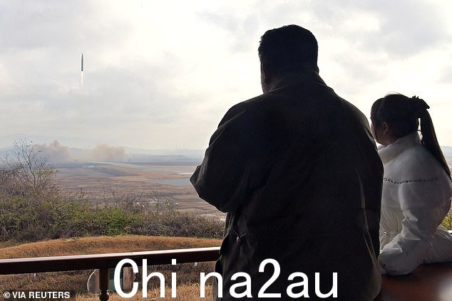 一家人远远地看着导弹发射升空(左)