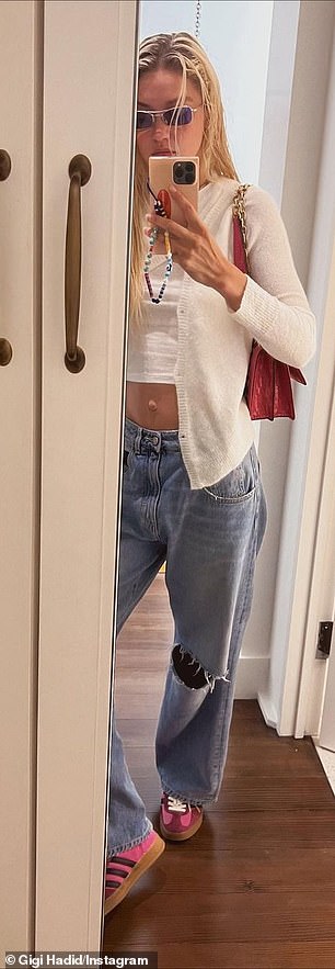 Gigi 还穿着一件白色短款上衣搭配开衫和她的低腰牛仔裤,再拍一张镜子
