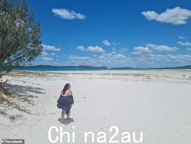 照片中亨德森女士在灾难性的公路旅行中沿着昆士兰远北的海滩散步