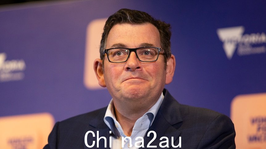 Daniel Andrews，穿着西装，在紫色卫生部门背景幕前对记者讲话。