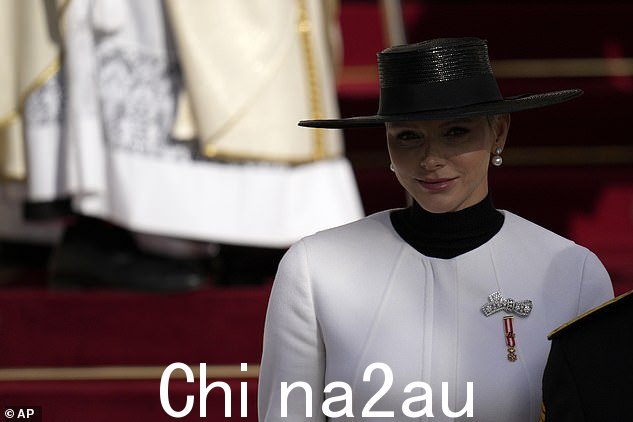 夏琳王妃戴着一顶宽边黑色帽子,搭配对比鲜明的亮白色裤装