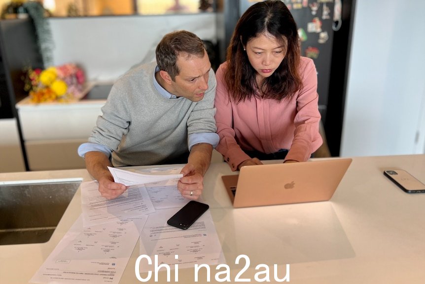 一个男人和一个女人看着笔记本电脑的屏幕。
