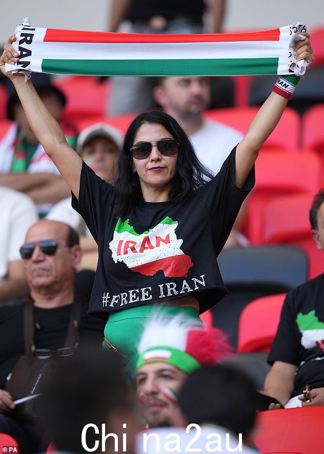 一名伊朗女子身穿印有“#FreeIran”字样的 T 恤,因为她的国家周五在 Ahmad Bi 举行的第二场小组赛中迎战威尔士n 卡塔尔的阿里体育场