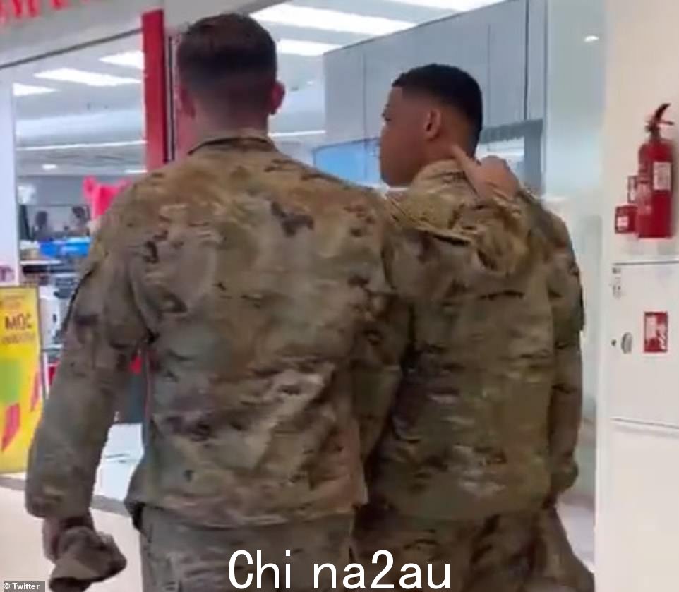 拍摄的男子对黑人士兵说'离那些白人妇女远点'后,他的一位朋友拍拍他的背安慰他,并继续把他推向出口