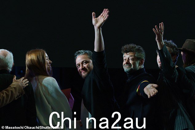 再见!指环王明星 Andy Serkis 向人群挥手致意,身穿彩色黑色夹克袖子上有 rful 条纹