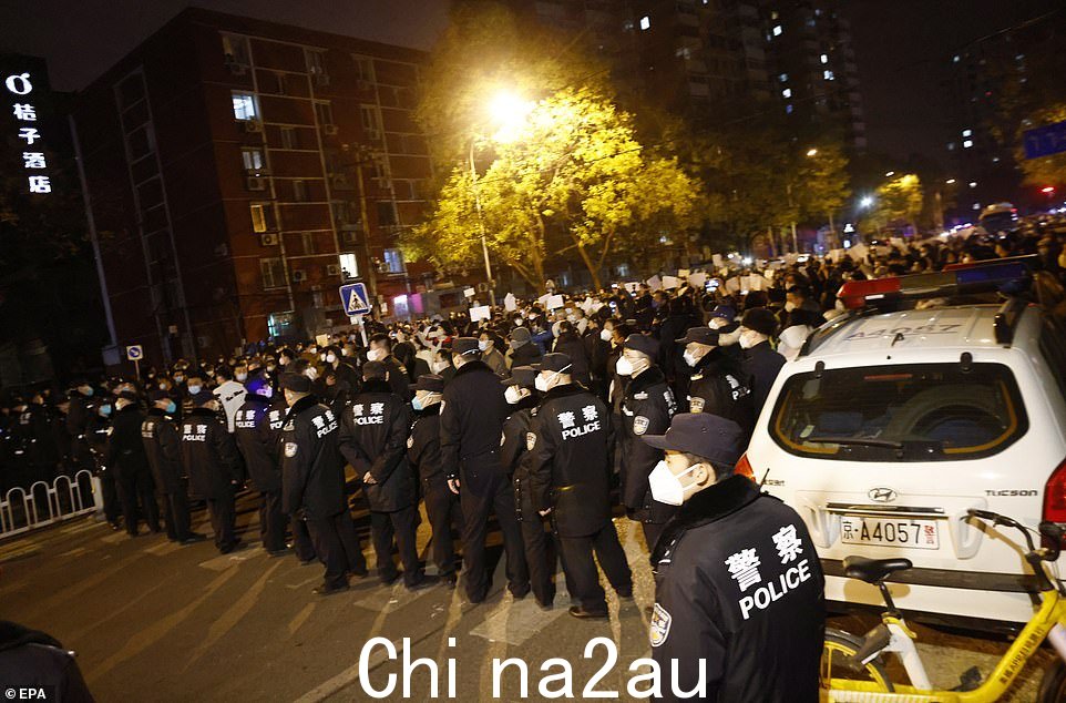 警关在中国北京乌鲁木齐火灾引发的抗议活动中,冰人封锁了一条道路,抗议活动仍在继续