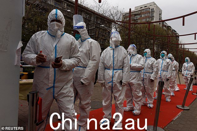 身穿防护服的工人出现在北京街头,因为中国正在使用封锁和大规模检测来镇压迄今为止规模最大的 Covid 疫情之一