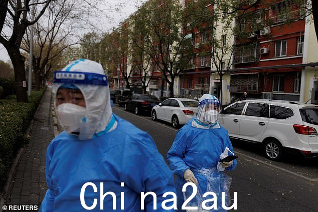 北京新冠病毒持续爆发,穿着防护服的男子走在街上