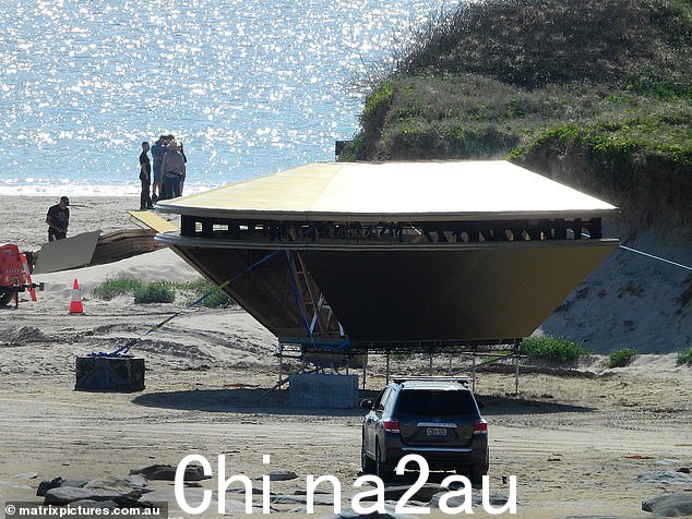 海滩上正在建造一艘太空船,上面有大量的船员周围的人