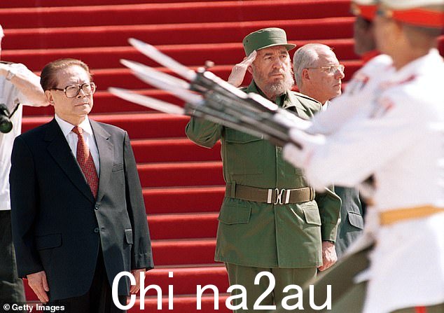 2001 年在哈瓦那革命宫,古巴总统菲德尔·卡斯特罗(右)与中国国家主席江泽民站在一起向仪仗队致敬
