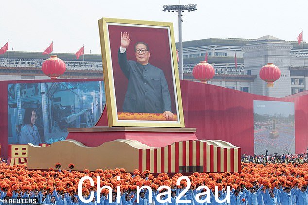 2019 年中华人民共和国成立 70 周年阅兵式上,天安门广场上的表演者站在展示江泽民的花车旁边