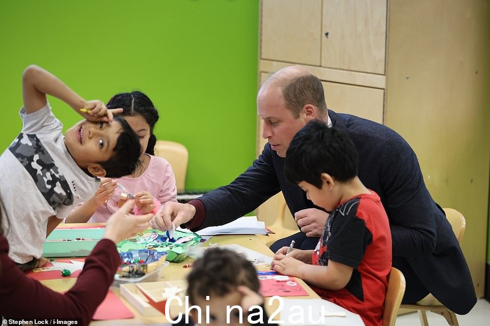 一个厚颜无耻的小男孩对着镜头做鬼脸,而威廉帮助另一个孩子oungster with his art project