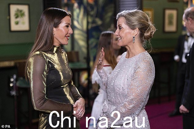 令人眼花缭乱:Ellie 穿着闪闪发光的绿色和金色连身衣,紧贴她轻盈的身材,看起来很迷人