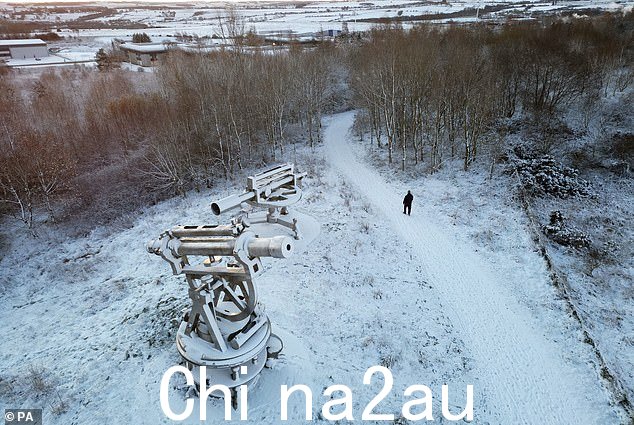今天早上,一名男子在达勒姆郡康塞特的 Terris Novalis 雕塑附近走过整夜的积雪