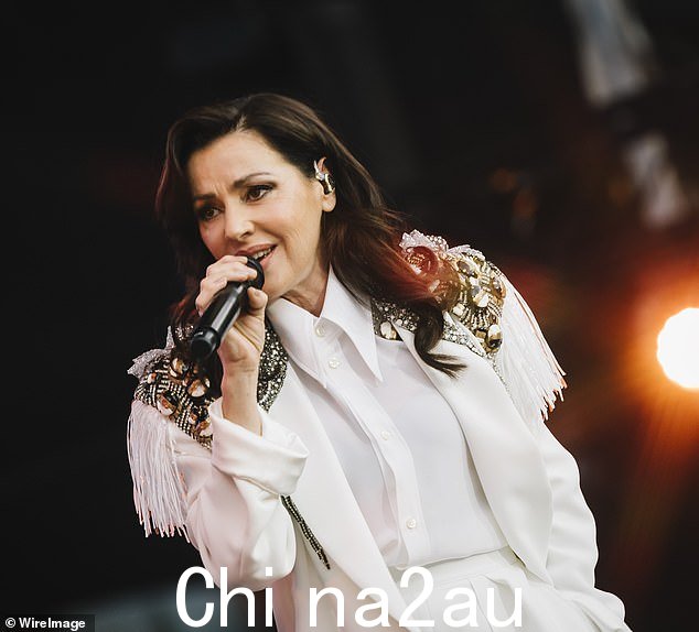 这位歌手卷曲了她的深色头发,化了整张脸,包括裸唇、腮红和眼线