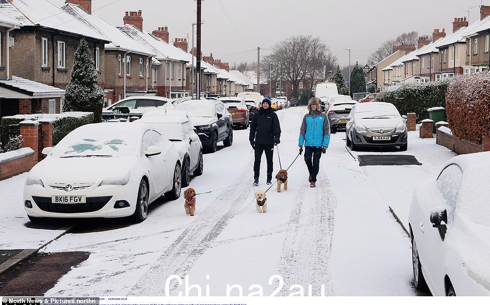 周日,在盖茨黑德的 Low Fell,遛狗者在寒冷的天气中冒着寒冷的雪地散步