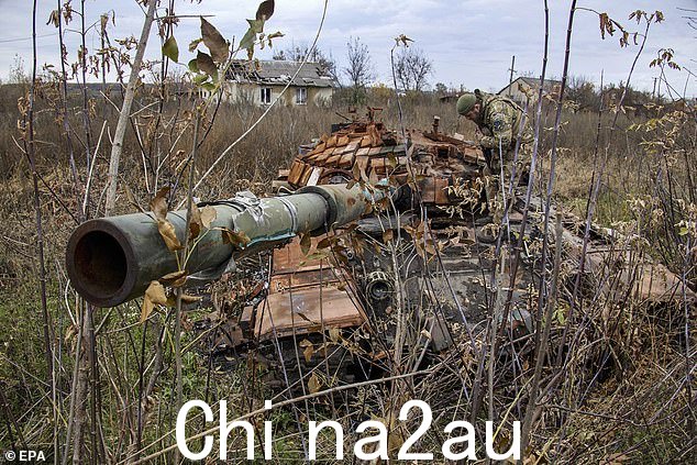 乌克兰国民警卫队的一名军人在 10 月检查乌克兰东北部哈尔科夫地区被摧毁的坦克