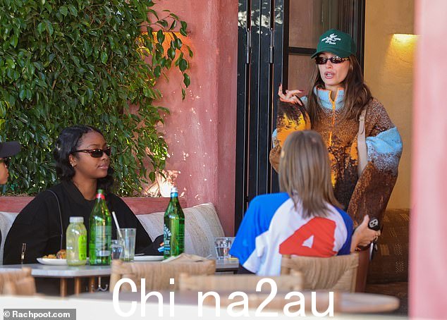 Trendsetter:Bieber 在一件带有夕阳设计的滚滚羊毛夹克下面穿了一条黑色机车短裤