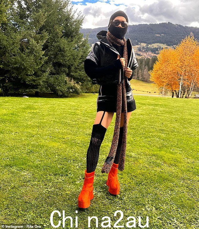 那不一样!32 岁的丽塔·奥拉 (Rita Ora) 周四在她最新的 Instagram 帖子中穿上了她迄今为止最大胆的装扮之一,将迷你迷你裙和吊带裤与一件大雨衣和巴拉克拉法帽组合在一起”课程=