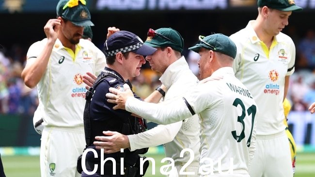 大卫战争纳尔和史蒂夫史密斯在致敬后拥抱了一位泪流满面的警官。图片：Chris Hyde - CA/Cricket Australia 来自 Getty Images