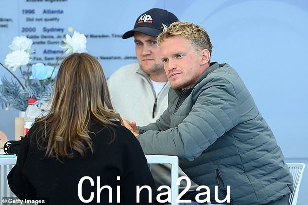 Cody 早些时候坐在泳池边,微笑着看着 Emma 参加比赛
