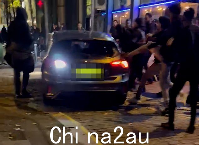 一段令人震惊的视频显示了一名司机逃离的那一刻,因为愤怒的人群撞毁了他的汽车