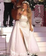玛丽亚·凯莉 (Mariah Carey) 在圣诞音乐会上坐在巨大的雪花中，一身白色令人惊叹