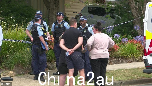 有人看到官员在家外采访震惊的当地人,同时他们互相安慰