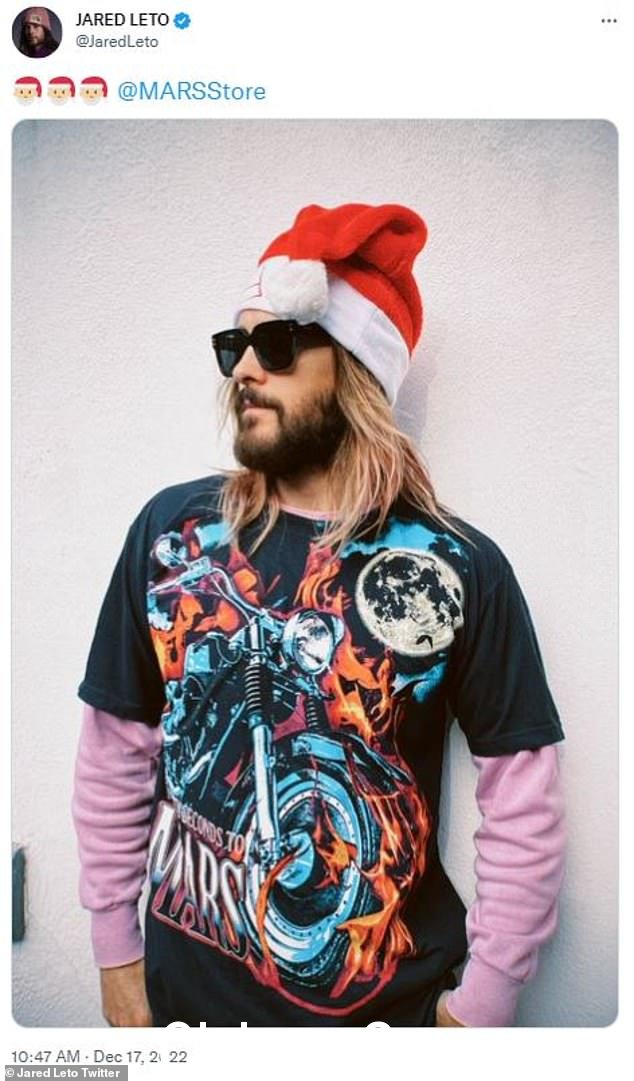 超越圣诞老人:50 岁的杰瑞德·莱托 (Jared Leto) 为他的乐队 30 秒上火星 (Thirty Seconds To Mars) 穿上了一件来自其商品店的 T 恤,并配上一顶经典的红白圣诞帽