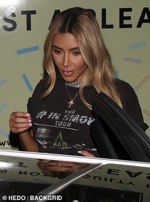 Golden girl:Kim 的金色发丝柔软地卷曲到她的腰部