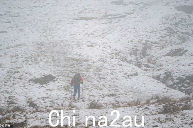 在威尔士的布雷肯比肯斯国家公园,一名徒步旅行者在下雨时爬上冰雪覆盖的山丘。冰雪席卷了英国部分地区,寒冷的冬季条件将持续数天。图片日期:Sunday December 18, 2022