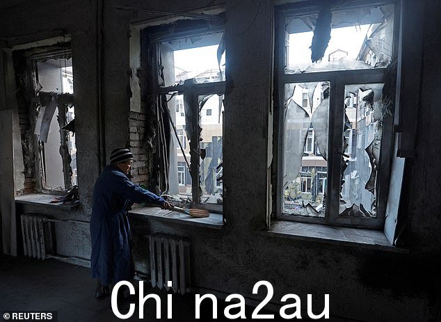 图:一名妇女在 2022 年 12 月 20 日在俄罗斯控制的乌克兰顿涅茨克最近因炮击而受损的医院内清除碎玻璃