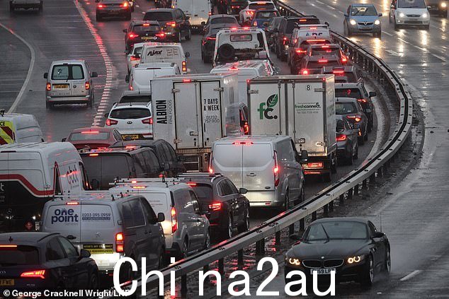 许多道路今天早上都有巨大的积水池,有些地方像湖泊,因为今天有近 1700 万旅客准备穿越英国。图为:今天早上在格林威治的 A102M Blackwall 隧道入口大雨期间交通排队