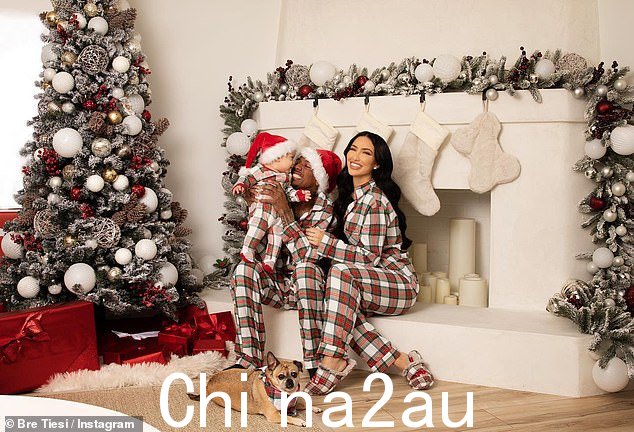 他像圣诞老人一样去拜访他的许多孩子:在装饰着三只长筒袜的奶油色壁炉的背景下,Cannon、Bre 和他们的新宝宝穿着相配的睡衣合影留念,合影留念