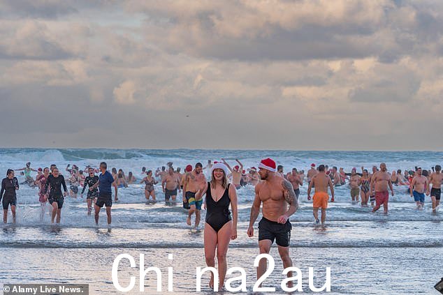 数百人涌入黎明后不久,康沃尔郡佩伦波思海滩的海浪——尽管没有多少人长时间留在冰冷的水域中