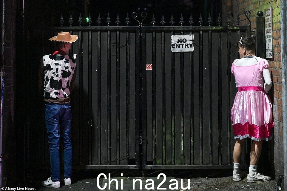 两个狂欢者,一个打扮成牛仔,另一个打扮成公主,在威根节礼日外出