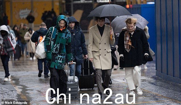 今天早上在帕丁顿车站周围的雨中的人们作为雨和湿衣服ther hits London