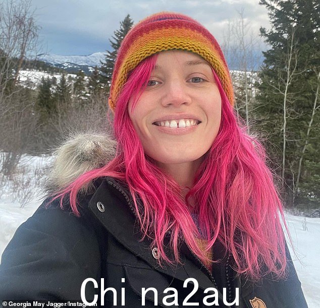 下雪天:Mick Jagger 的女儿穿着一件带蓬松兜帽和彩色条纹帽子的大衣,在寒冷的天气中保暖