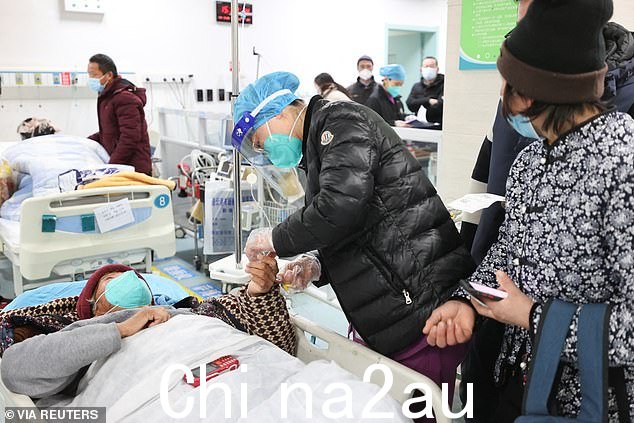 12 月 28 日,在中国东北连云港市赣榆区人民医院急诊科,一名医务人员在 Covid 爆发期间照顾病人
