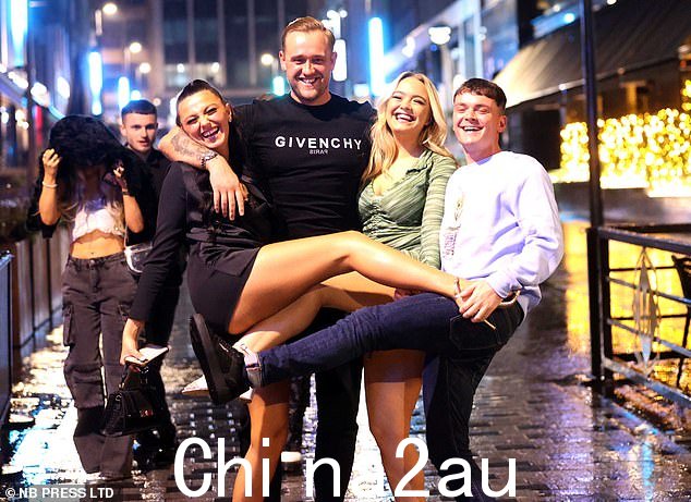 两个女人和两个男人正在享受新年前夜的庆祝活动。一个男人穿着纪梵希上衣,另一个男人穿着白色套头衫,他们微笑着迎接新年