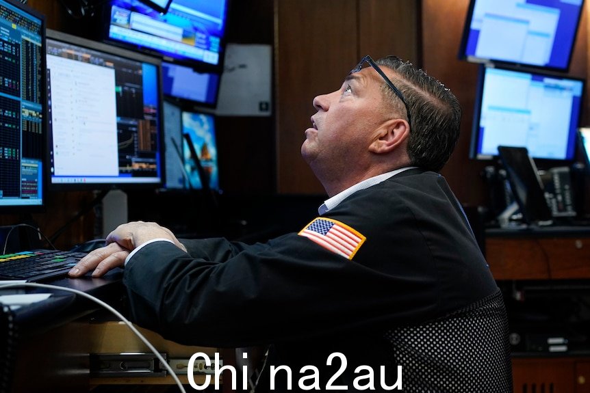 纽约证券交易所成员坐在办公桌后面的交易所交易员抬头看着电脑显示器