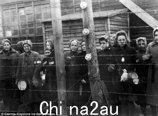1945 年,德国 Ravensbruck 集中营的囚犯站在铁丝网附近,这一年有 2,500 名妇女在一个周末因俄罗斯军队接近而被谋杀