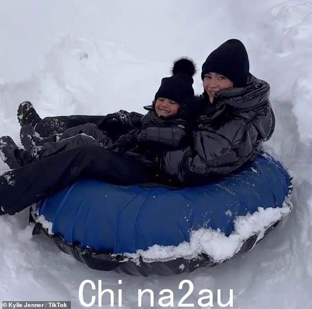 太可爱了:这对可爱的人穿着配套的黑色羽绒服、毛线帽和雪裤