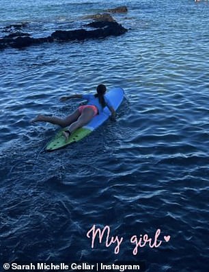 溺爱妈妈:这位骄傲的妈妈确保将她的女儿包括在内,选择展示她躺在海中的冲浪板上,海水在她周围荡漾