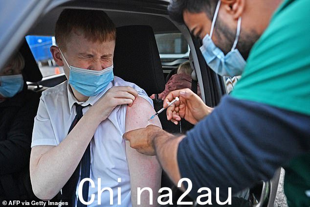 论文本身,p发表于 12 月 5 日,支持的证据表明,疫苗对预防年轻人患重病几乎没有什么好处,年轻人面临着来自病毒本身的微小威胁。图为一名年轻人在布莱克本的得来速中心接种疫苗