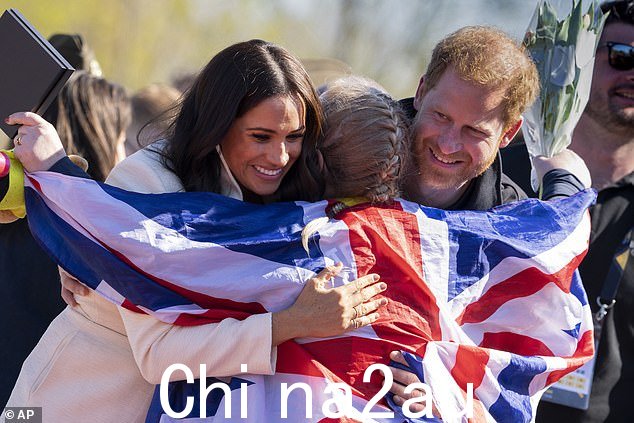 4 月 17 日星期日,在荷兰海牙的 Invictus Games 场地,哈里王子和梅根·马克尔、苏塞克斯公爵和公爵夫人拥抱前军医和截肢者丽莎·约翰斯顿,她拿着奖牌庆祝, 2022