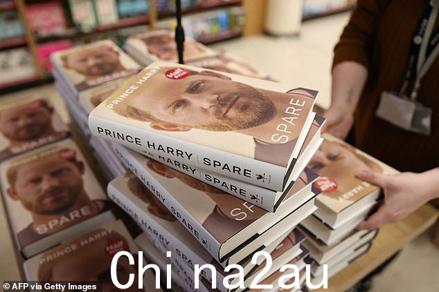 WHSmith at Victoria in London 的一名工作人员打开 Spare 副本准备展示