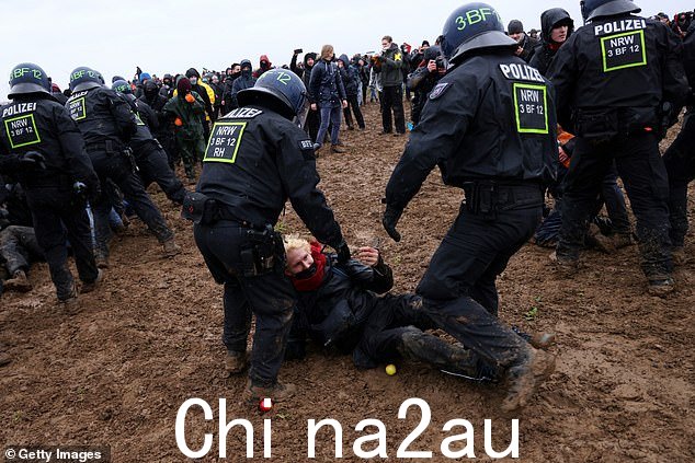 一名抗议者在 1 月 14 日星期六在煤矿与警察和生态活动家发生冲突时倒地