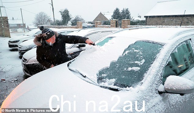 星期一早上,一名男子在达勒姆郡开始除冰和清除汽车上的积雪