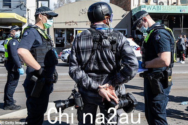 虽然维州警方洗清了这名警官的不当行为,但他们还与 Ascui 先生就去年的事件达成了数千澳元的私下和解(如图,2021 年 9 月 18 日集会的图片)